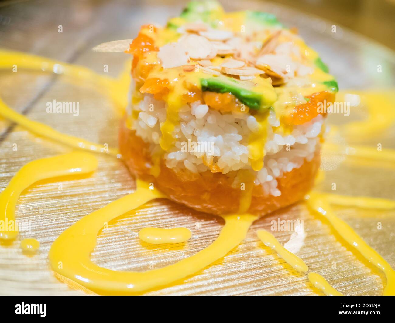 Typisch japanisches Gericht mit Sushi, Reis und Fisch, mit Sauce, Salat, Sushimi und Sesam. Japanischer Burger mit Reis, Lachs, Avocado, Mandeln und d Stockfoto