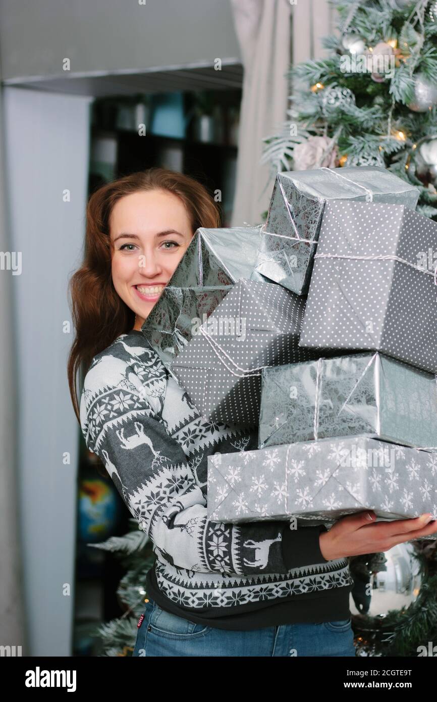 Schöne lächelnde Mädchen mit einem Haufen von Geschenken in der Nähe der weihnachtsbaum - weihnachten und Neujahr Konzept. Stockfoto