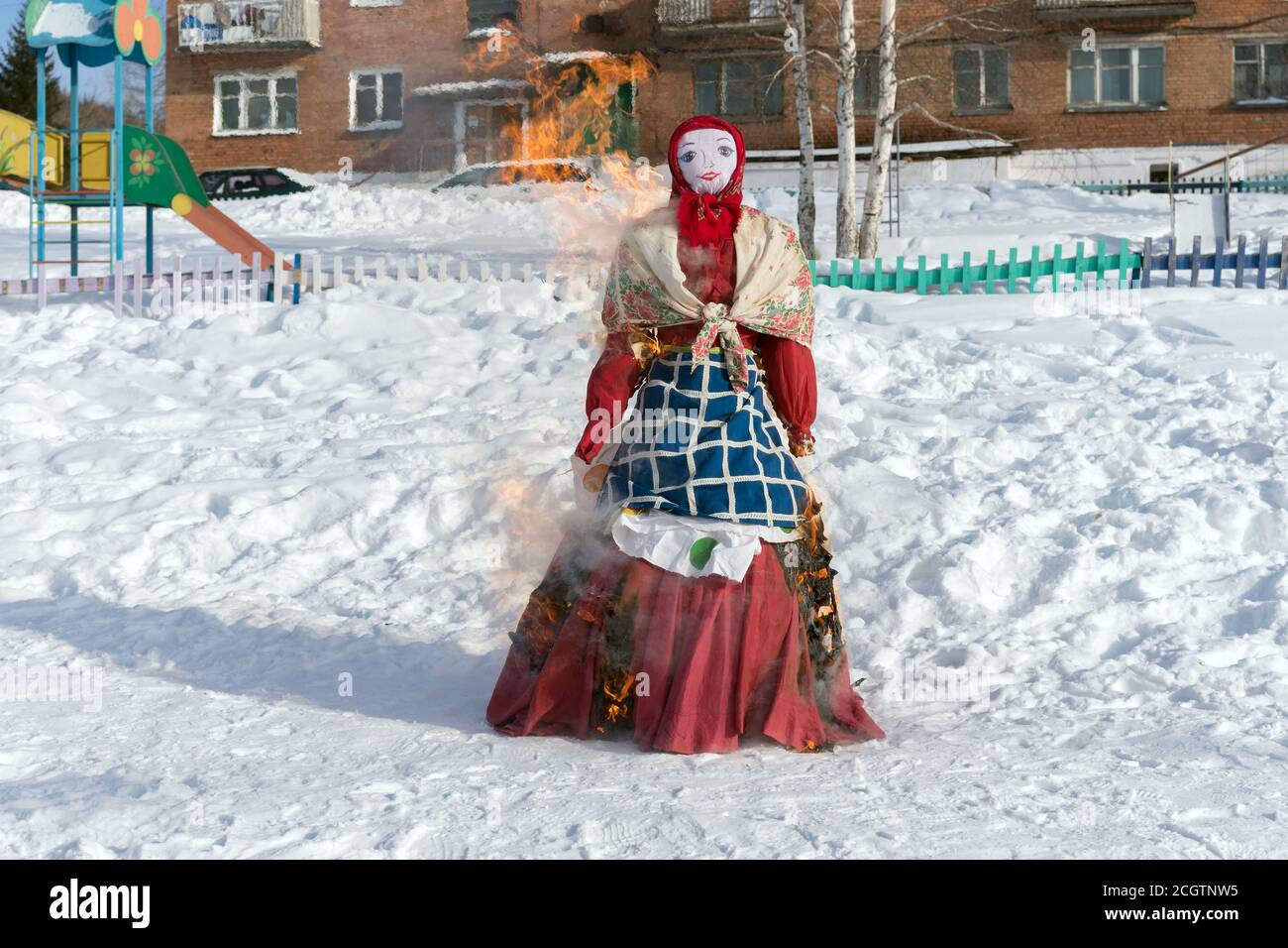 Das Bildnis der Schrovetide in russischer Volkstracht wird im Schnee während eines traditionellen nationalen Feiertags der Absehung von russischen Mutterwintern verbrannt. Stockfoto
