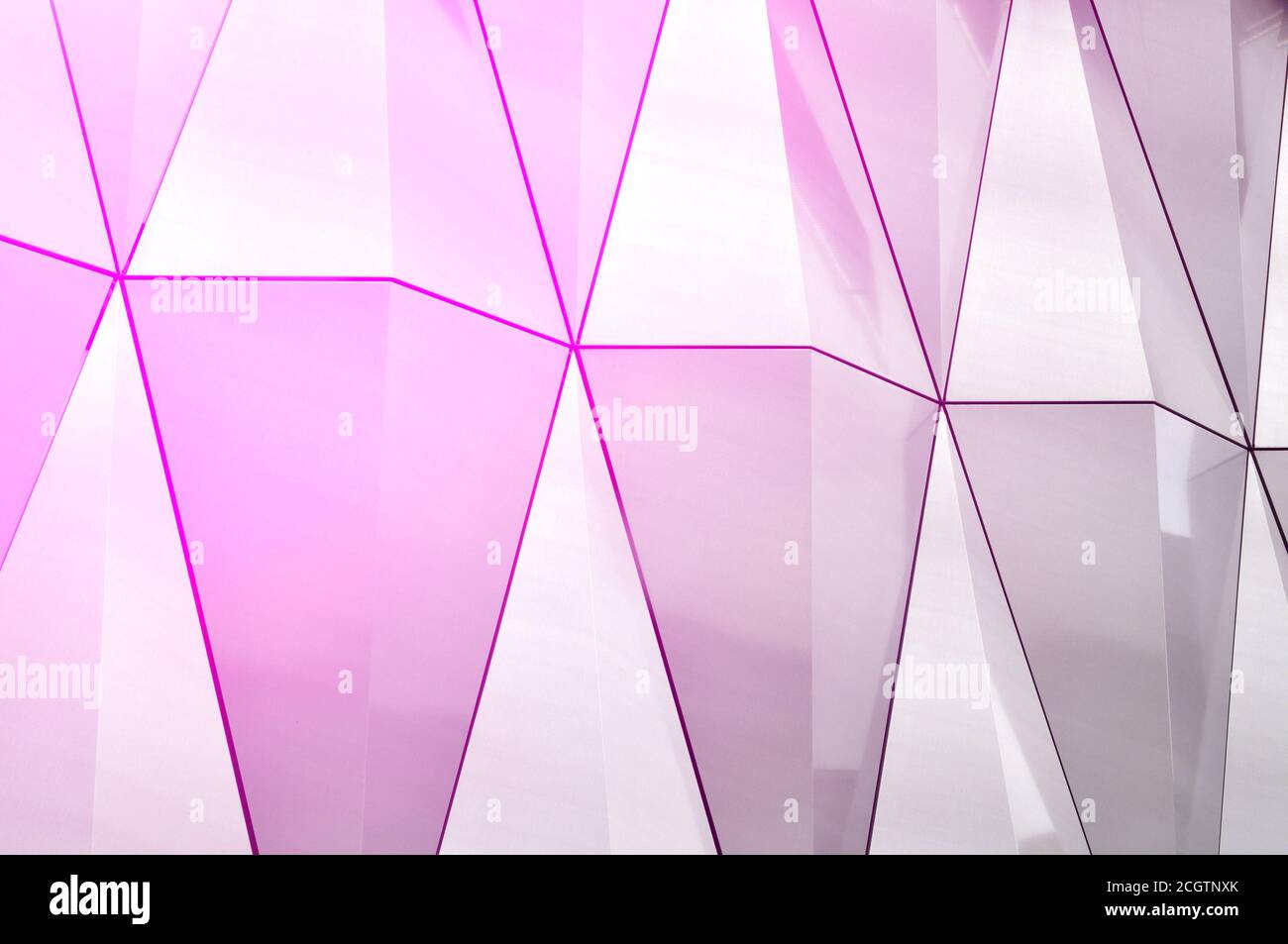 Spiegelfläche aus Edelstahl mit Kristallen in der Wand, Dekor und Reflexion. Abstrakter Glashintergrund. Polygonale Oberfläche. Stockfoto
