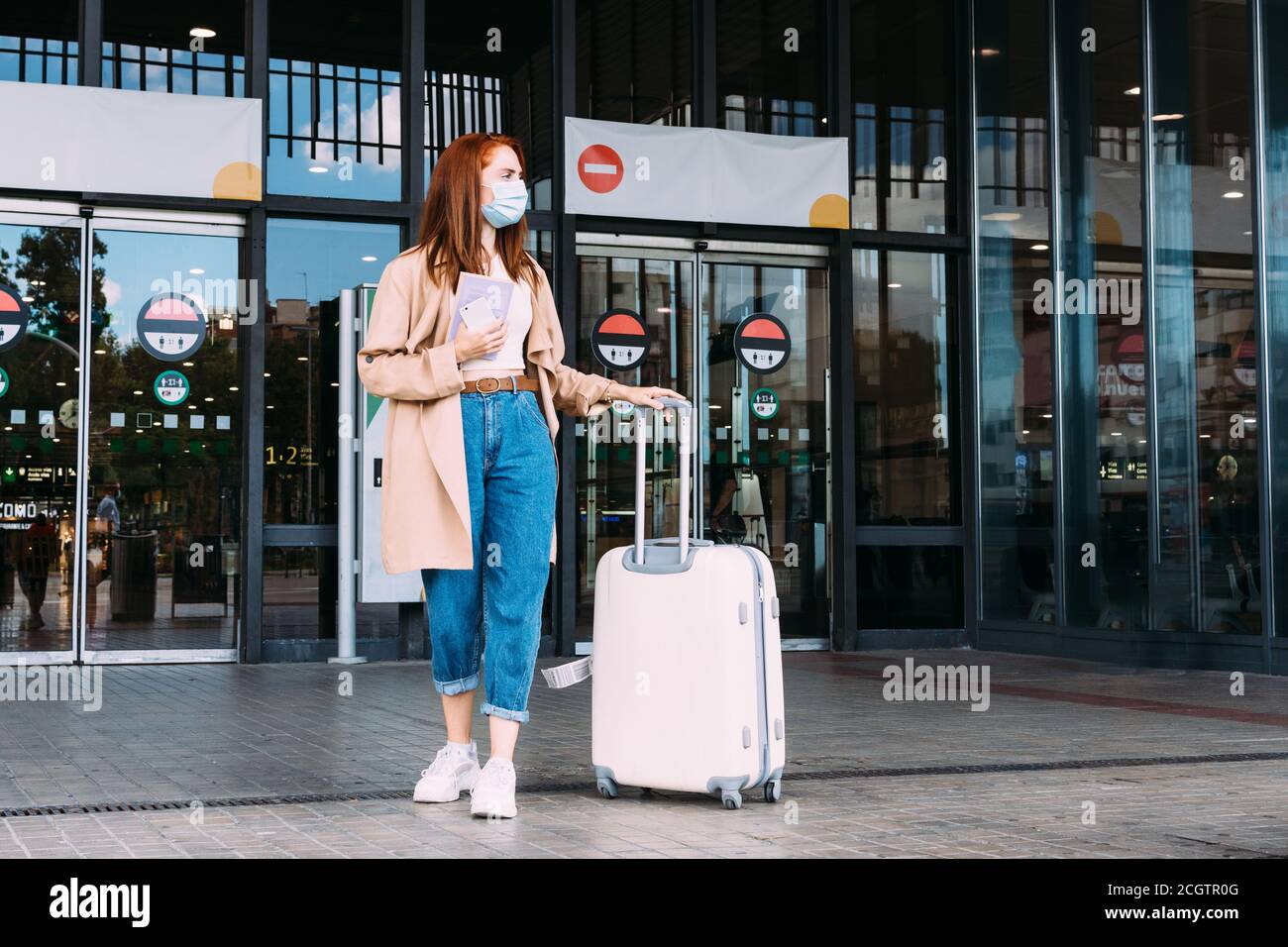 Tourist mit Gesichtsmaske verlässt den Bahnhof tragen Sein Gepäck Stockfoto