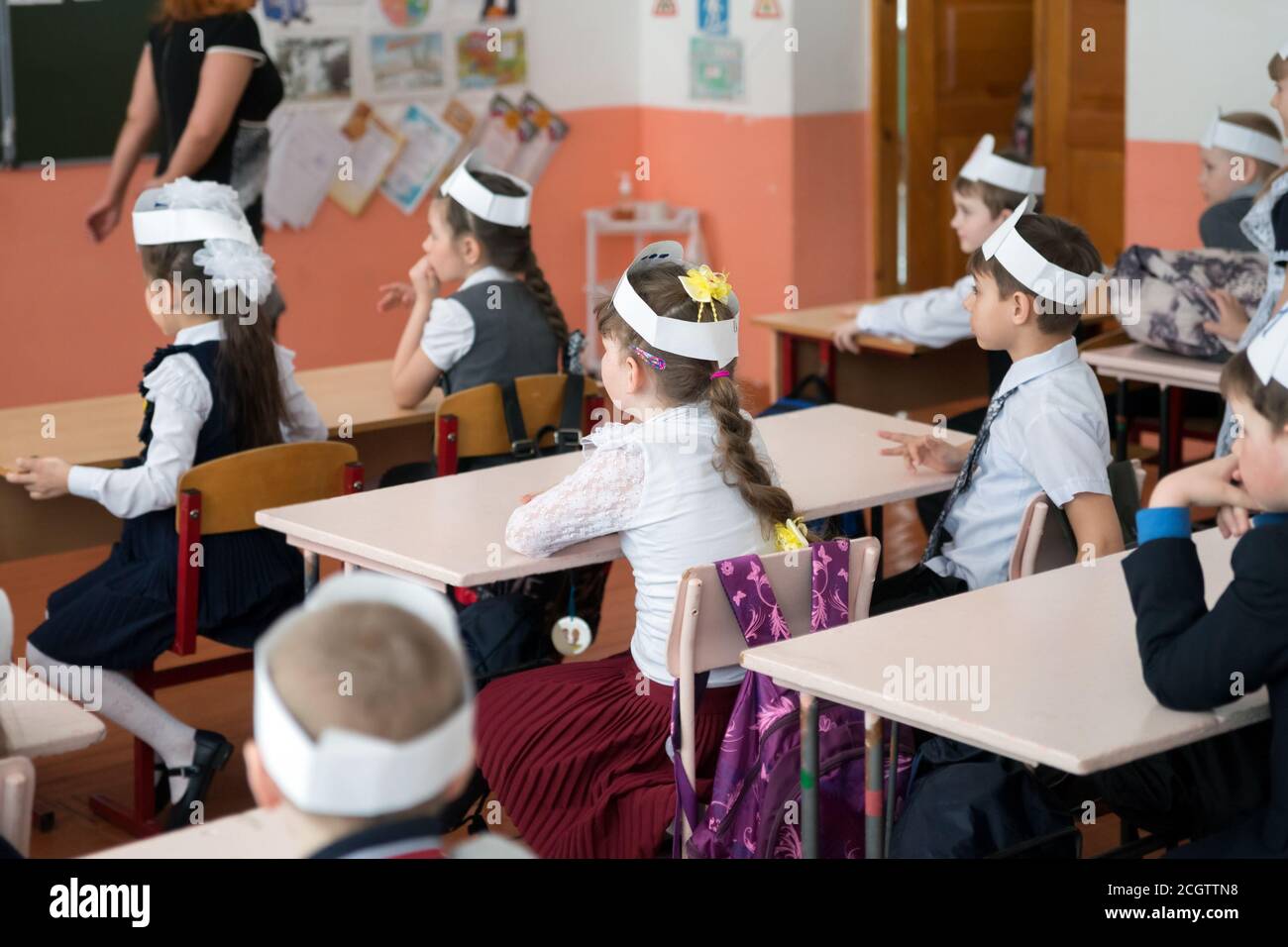 BELOGORSK, REGION KEMEROWO, RF- März 22,2018: Die ersten Former sitzen am Schreibtisch und schauen auf den Lehrer in der Schulklasse, in der ländlichen Grundschule. Stockfoto