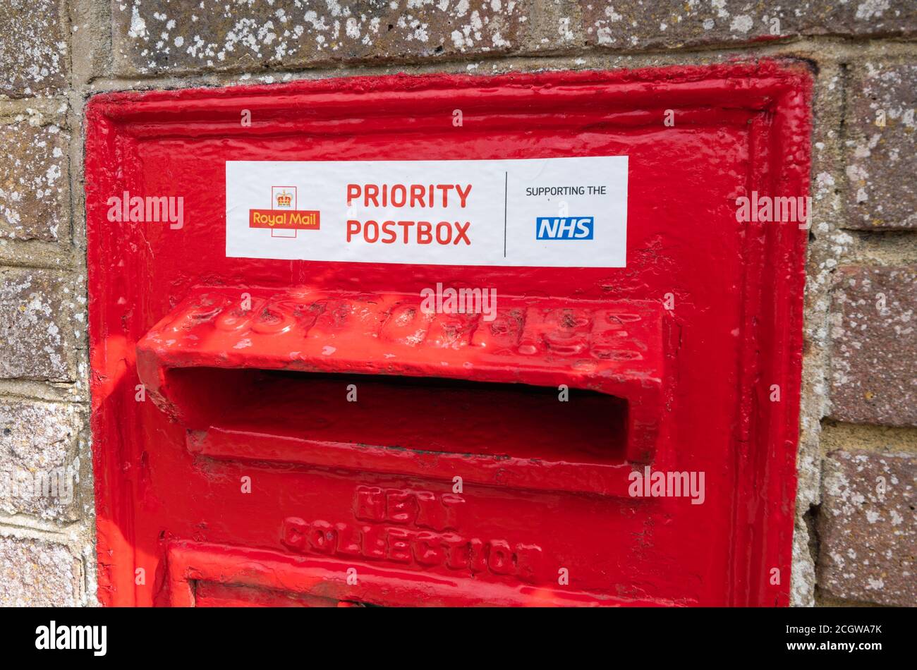 Priority Postbox, eine rote Royal Mail an der Wand montierte Postbox (Postbox, Briefkasten, Briefkasten, Briefkasten) während der COVID19 Coronavirus Pandemie in England, Großbritannien. Stockfoto