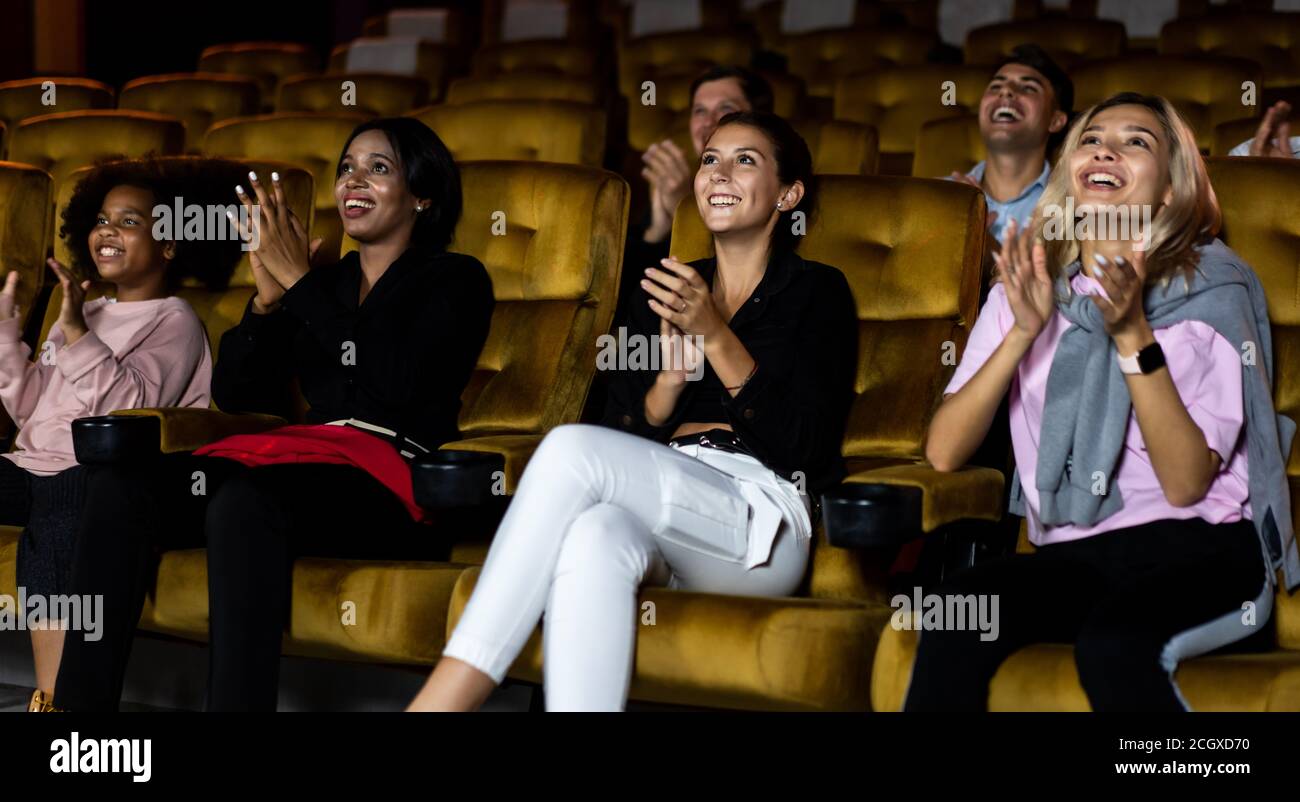 Eine Gruppe von Zuschauern, die im Kino glücklich und lustig sind. Gruppenfreizeitprogramm und Unterhaltungskonzept. Stockfoto