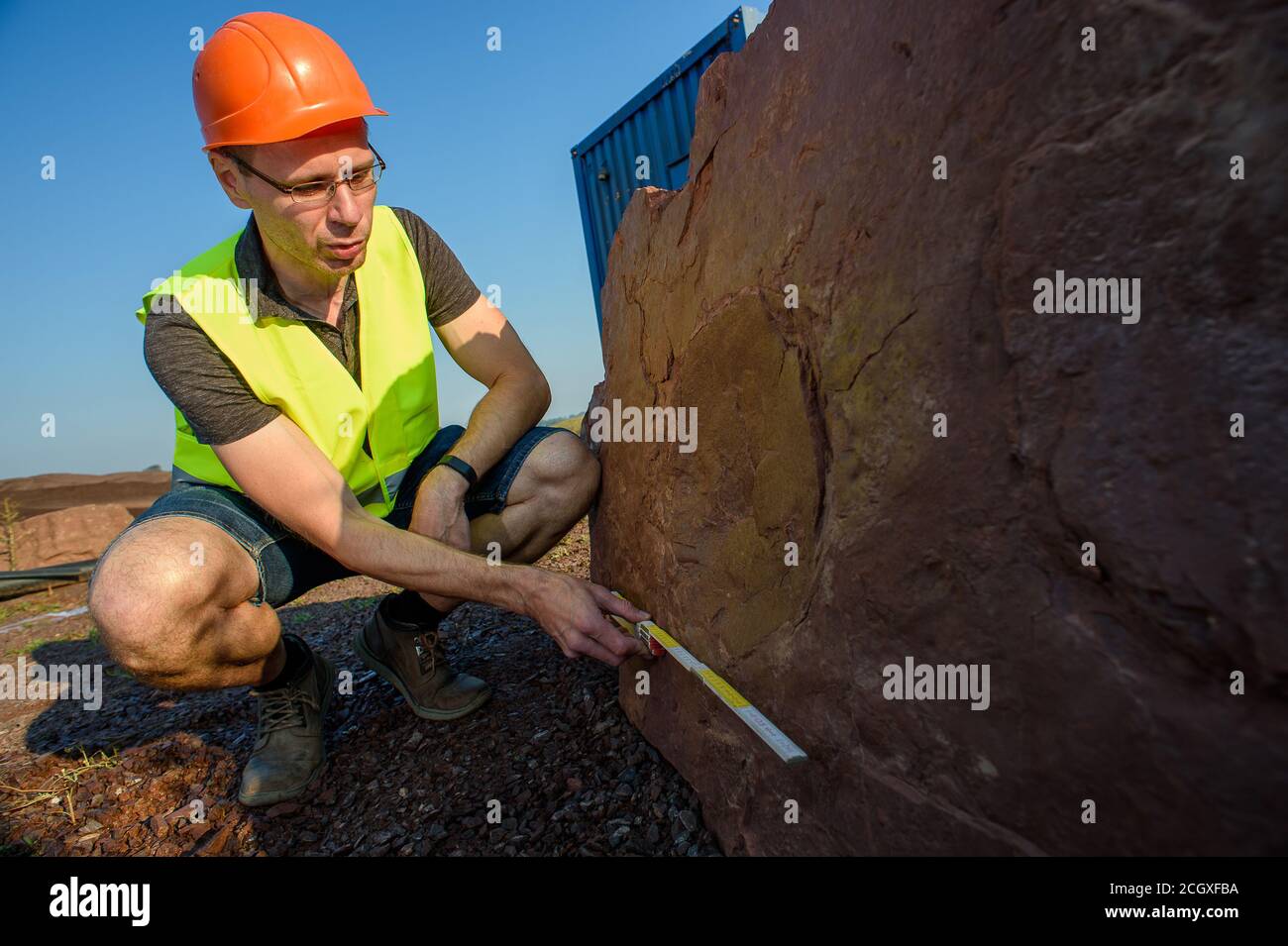 Mammendorf, Deutschland. August 2020. Michael Buchwitz, Kurator für Geowissenschaften am Museum für Naturkunde Magdeburg, misst im Steinbruch mammendorf den Abdruck eines Pareia-Dinosauriers mit Faltregel. Die Spur war vor etwa 260 Millionen Jahren vom Dinosaurier in den lehmigen Boden gepresst worden. Seit 2016 suchen Wissenschaftler regelmäßig nach Dinosaurierspuren in den Schlachtscheifen des Steinbruchs. (To dpa 'Scientists find more and more dinosaurier Tracks in the Mammendorf Quarry') Quelle: Klaus-Dietmar Gabbert/dpa-Zentralbild/dpa/Alamy Live News Stockfoto