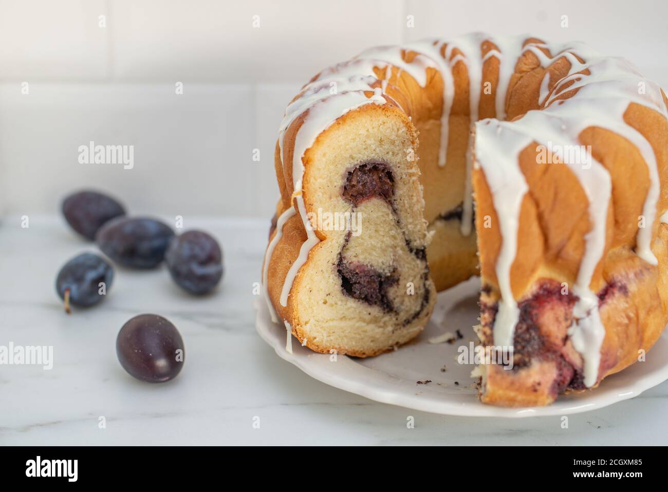 deutscher Gugelhupf Kuchen gefüllt mit Mohn und Pflaumen Stockfoto