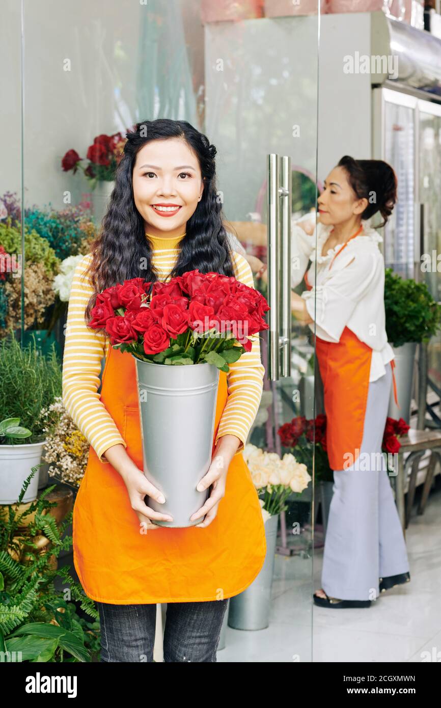 Blumenhändler mit Eimer roter Rosen Stockfoto