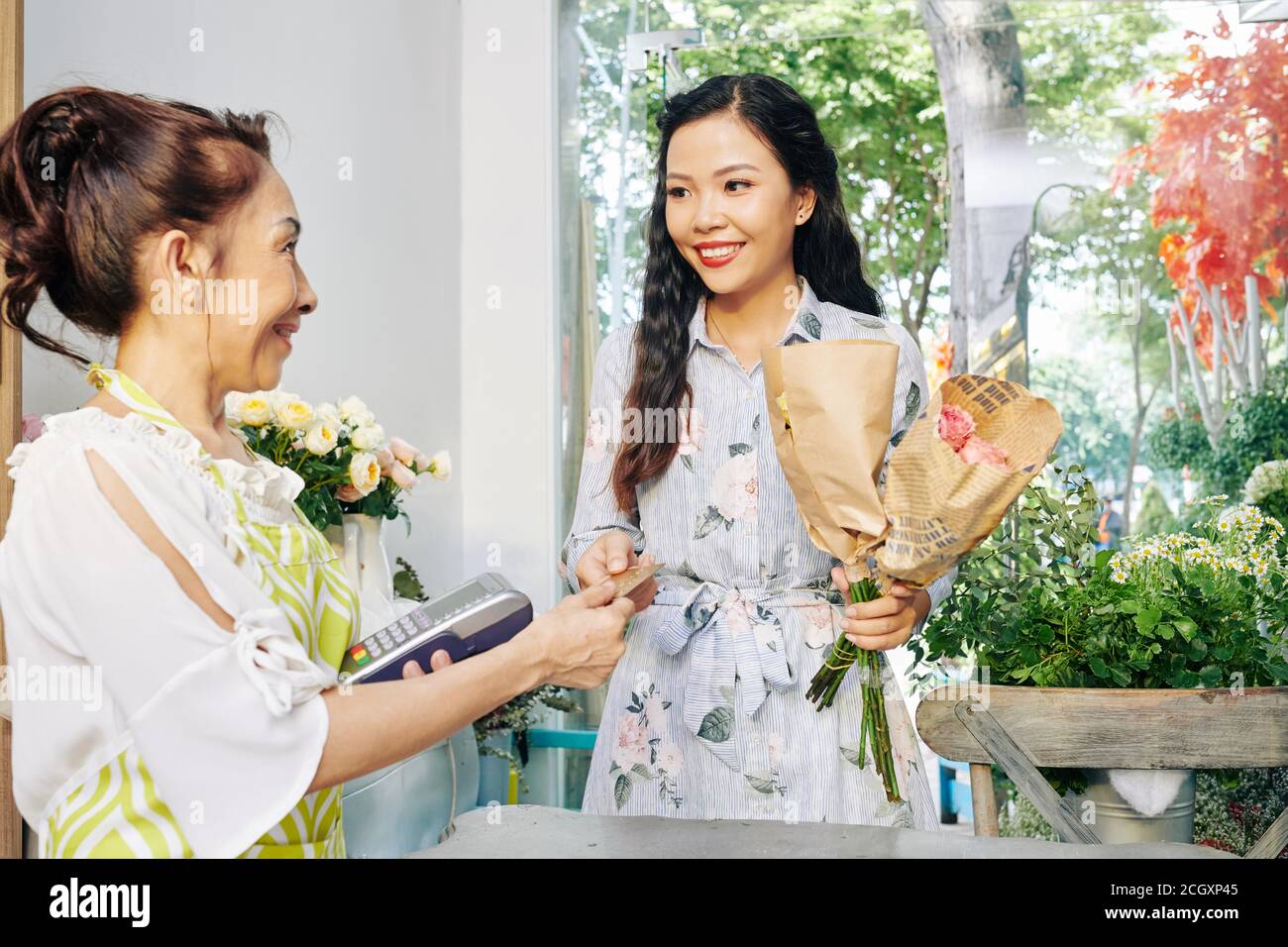 Frau kauft Blumen im Geschäft Stockfoto