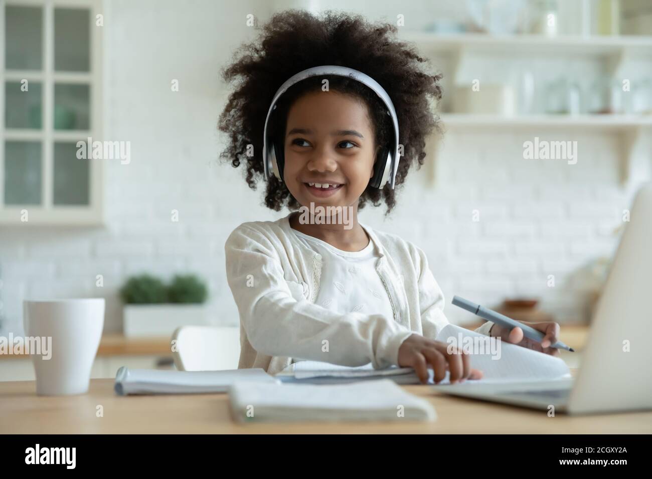 Abgelenkt von E-Learning glücklich gemischt Rennen Kind wegschauen. Stockfoto
