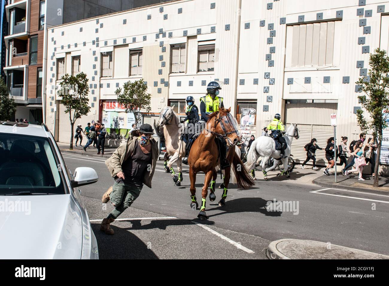 Melbourne, Australien. September 2020. Demonstranten laufen, während Polizisten aus Victoria auf eine Gruppe einziehen, die während eines Anti-Maske- und Anti-Lockdown-Popupproteste in Melbourne Australien in den Straßen um die Queen Victoria Markets herum marschiert war. Kredit: Michael Currie/Alamy Live Nachrichten Stockfoto