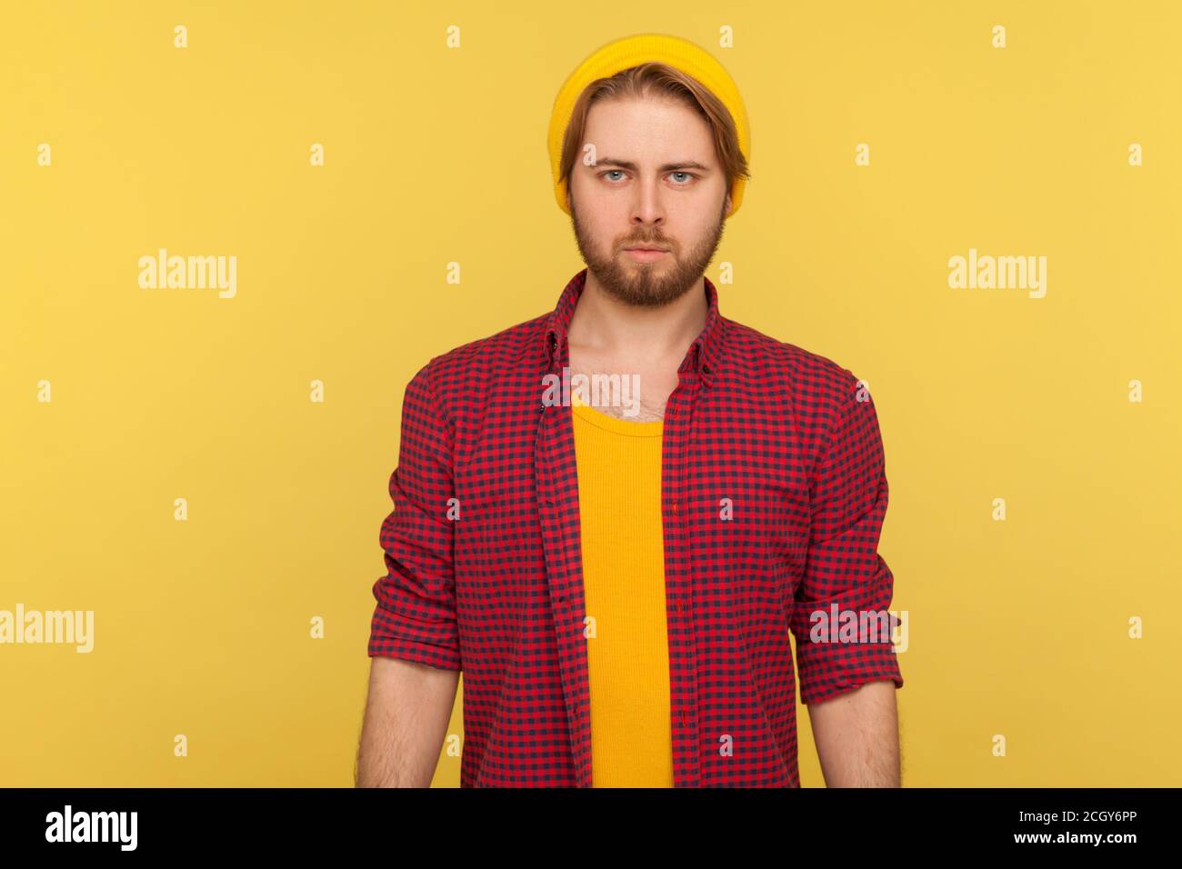 Serious Hipster bärtig Kerl in Mütze Hut und karierte Hemd Blick auf die Kamera mit selbstbewussten selbstbewussten Gesicht, ruhig aufmerksam ernsthaft Ausdruck. ich Stockfoto