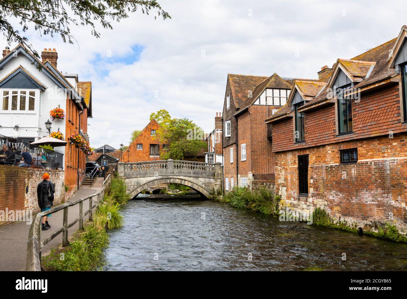 Der Fluss Itchen fließt durch die Wehre in Winchester, Hampshire, Südengland Blick in Richtung City Mill und der historischen Steinbrücke Stockfoto