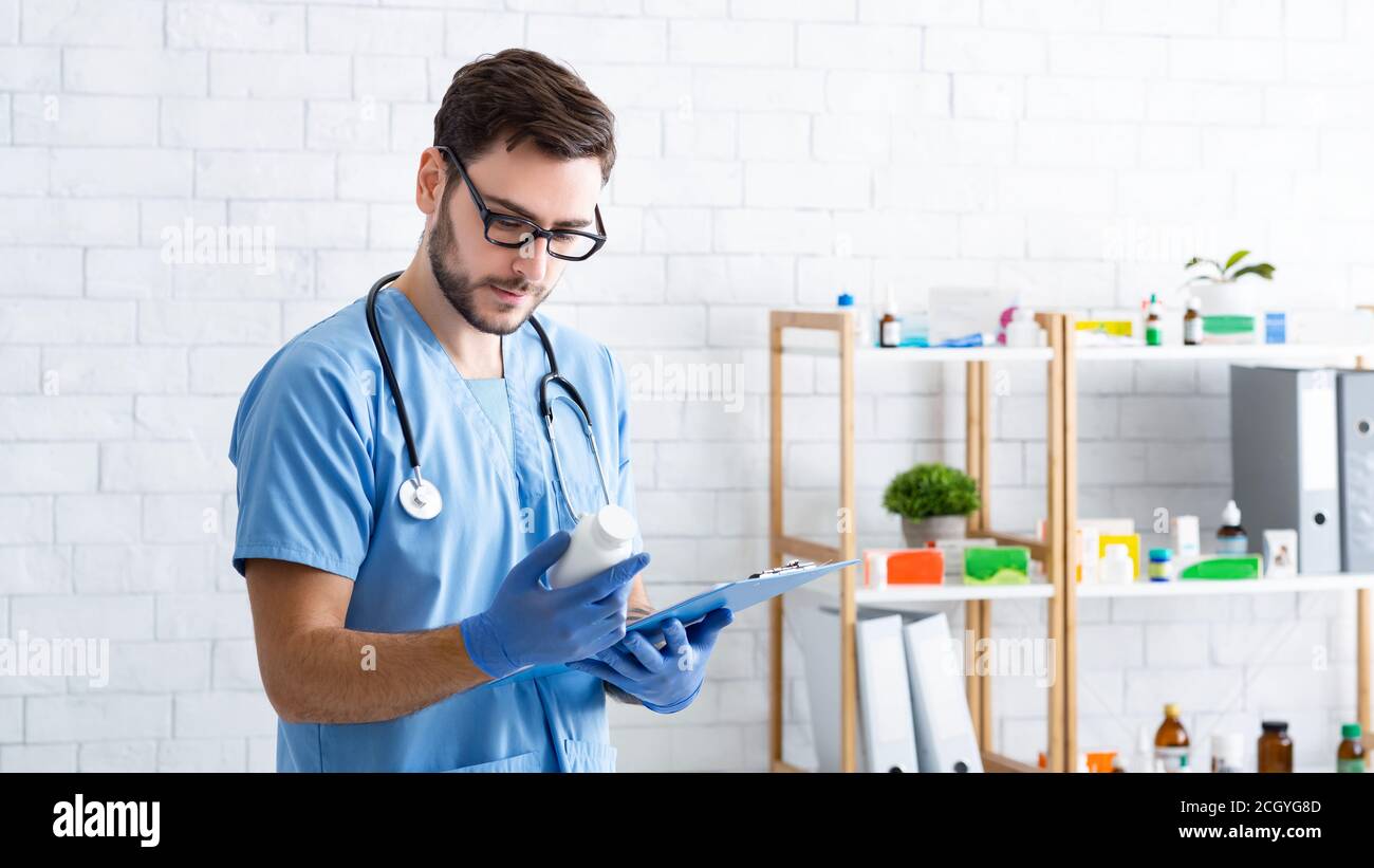 Professionelle männliche Tierarzt mit verschreibungspflichtigen Pillen und Zwischenablage in der Tierklinik, Leerzeichen Stockfoto