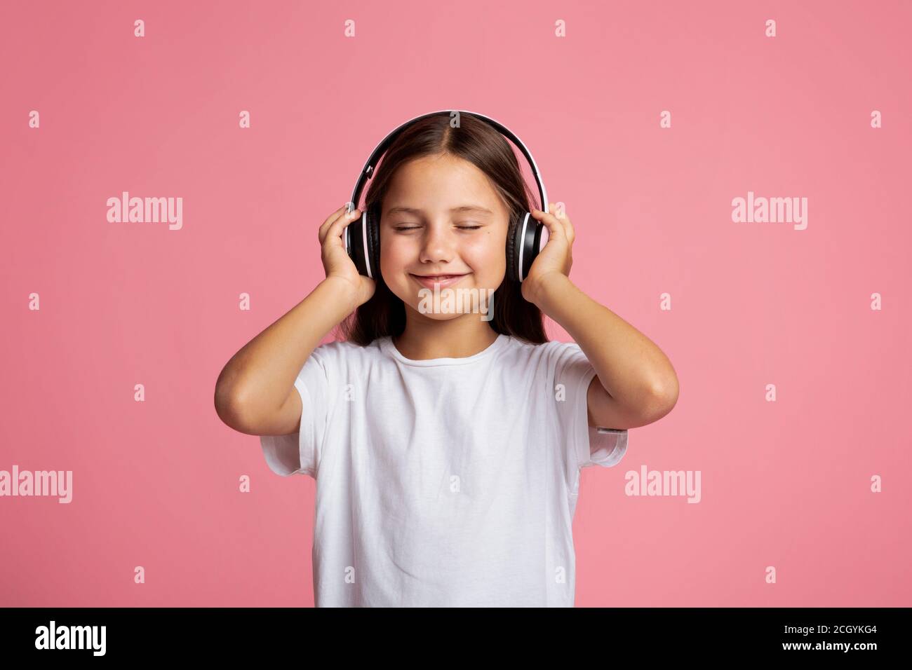 Moderne Kinder und Geräte. Kleines Kind mit geschlossenen Kopfhörern und Musik genießen Stockfoto