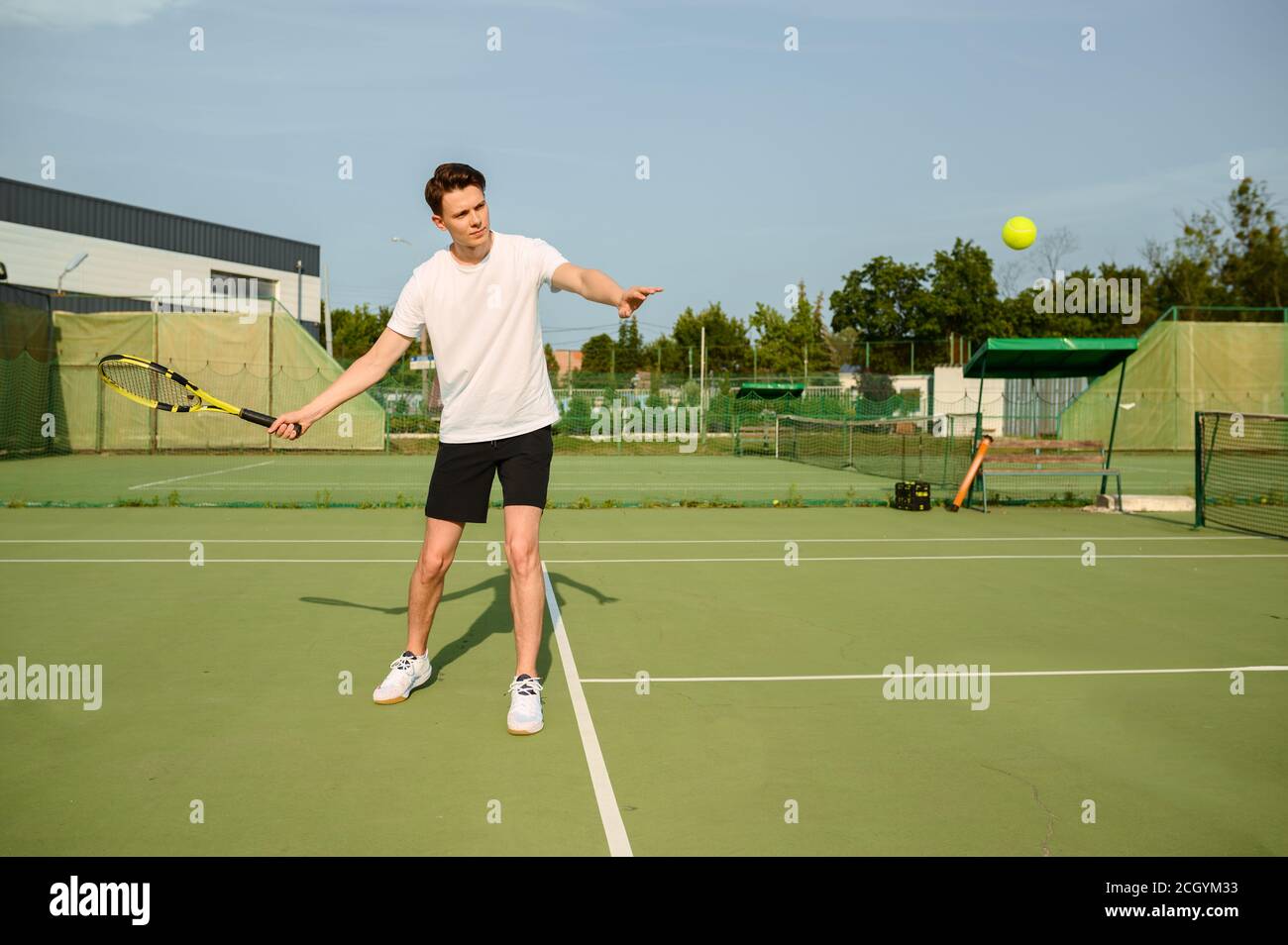 Männlicher Tennisspieler mit Schläger trifft den Ball Stockfoto