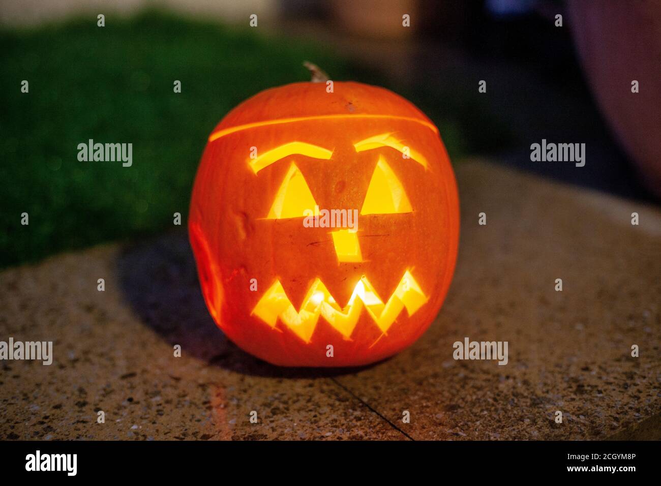 Ein geschnitzter Kürbis mit einer Teelicht Kerze beleuchtet sitzt im Garten bei Halloween in Dorset, UK.. 30. Oktober 2011. Foto: Neil Turner Stockfoto