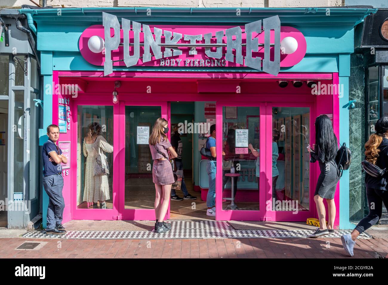 Brighton, Großbritannien. 12. September 2020.Menschen warten vor einem Piercing Shop in Brighton City Centre Credit: Andrew Hasson/Alamy Live News Stockfoto