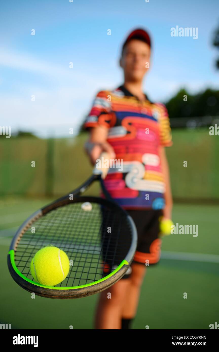 Männliche Tennisspieler posiert mit Schläger und Ball Stockfoto