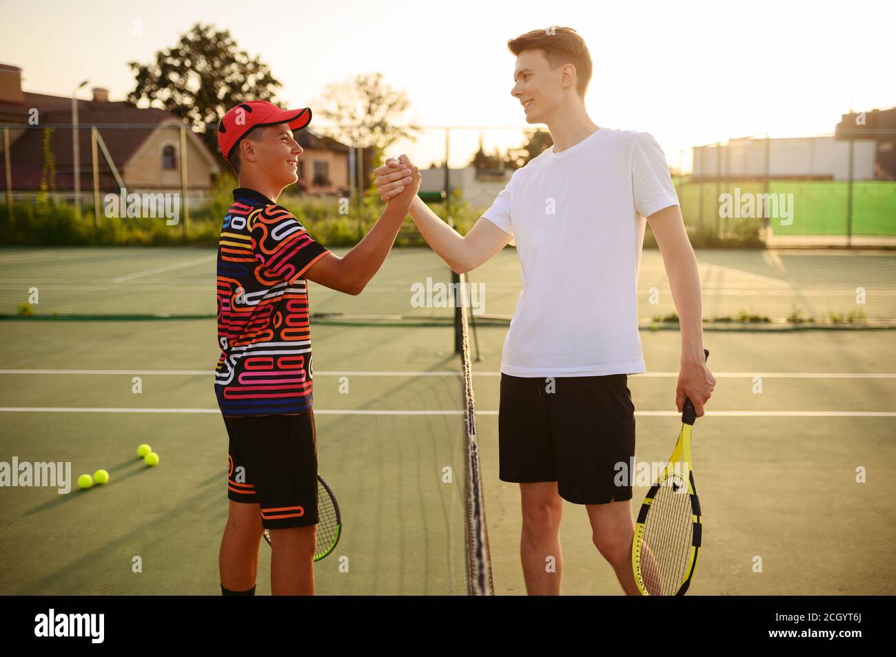 Tennisspieler mit Schlägern schütteln sich die Hände am Netz Stockfoto