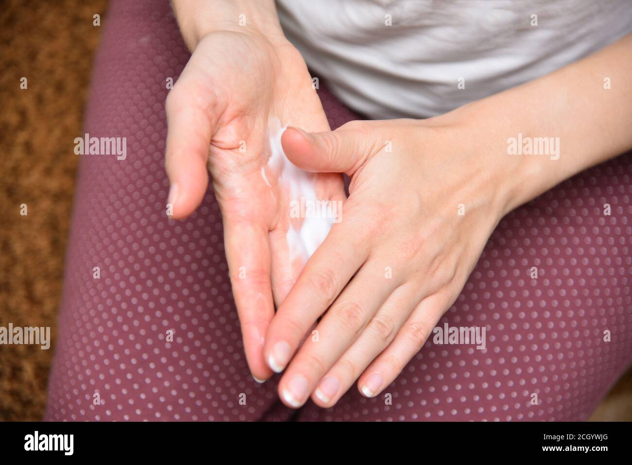 Mädchen mit Creme auf den Händen Nahaufnahme. Creme auf die Handfläche geben. Stockfoto