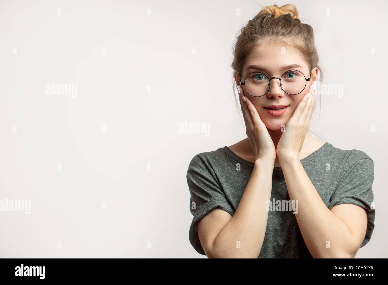 Schockiert überrascht Frau mit runden Augen in Brille Blick auf die Kamera, die Hände angehoben, um Gesicht, erstaunt zu hören, dass Verkauf auf Wohnung käuflich Stockfoto