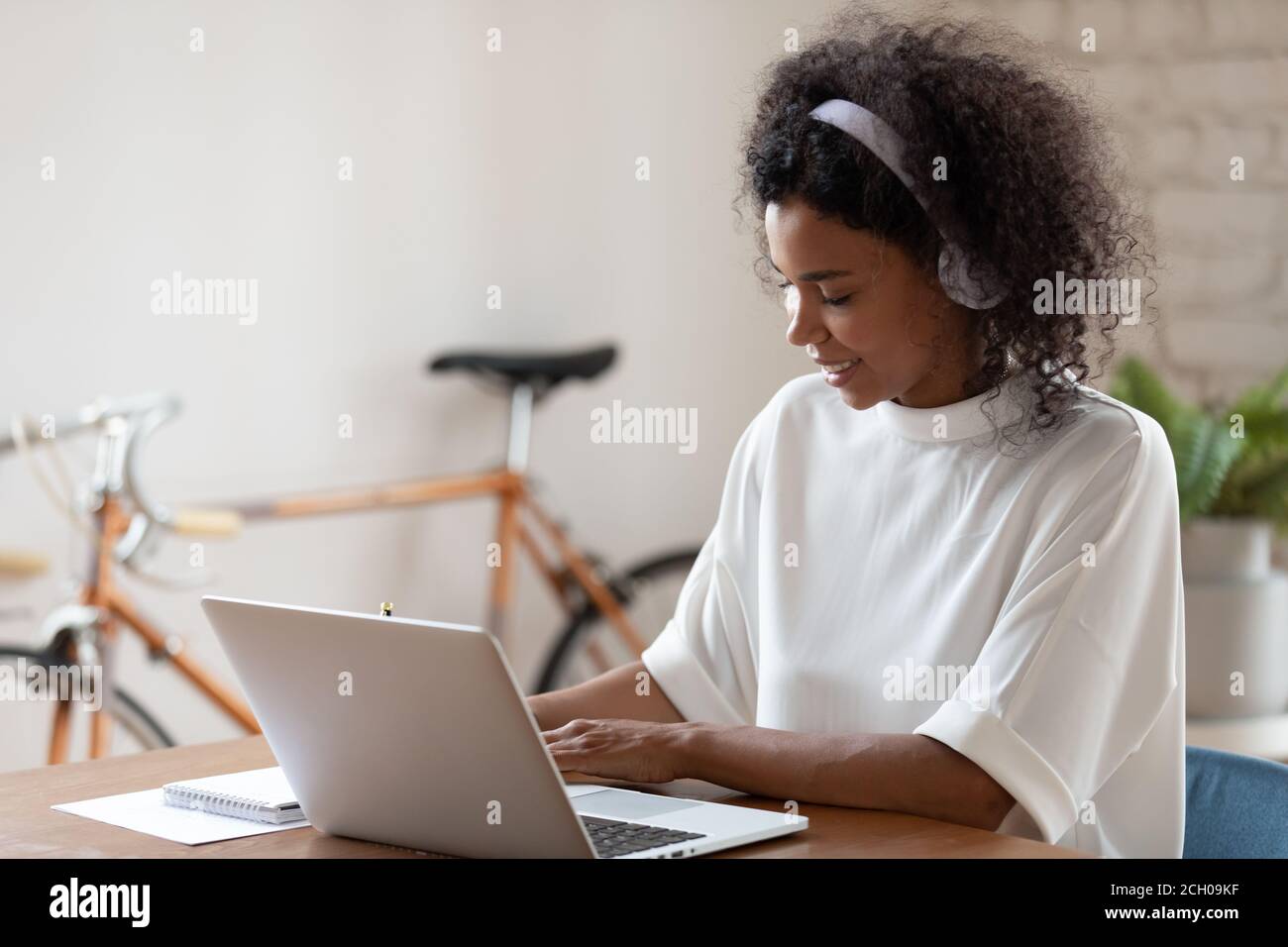 Afroamerikanische junge Frau mit Kopfhörern Online-Training ansehen Stockfoto