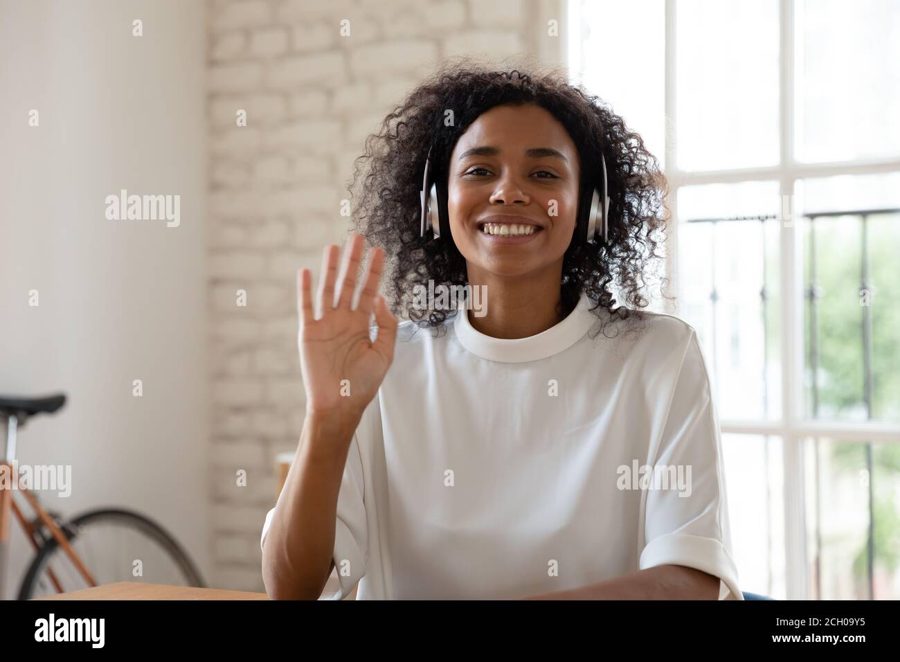 Lächelnd biracial Frau Welle mit Videoanruf im Büro Stockfoto