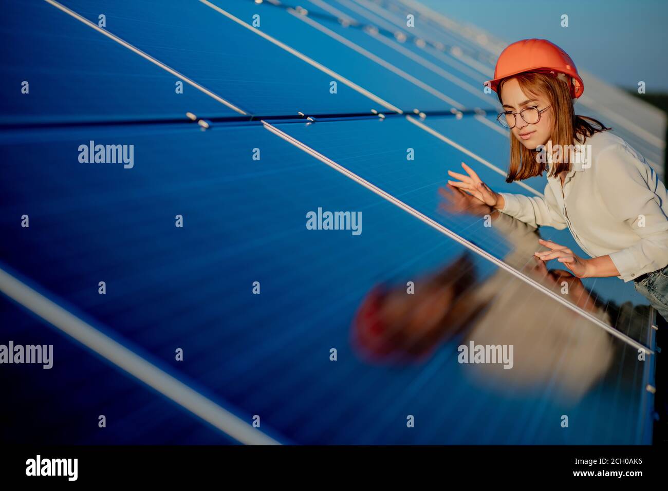 Schöne junge Ingenieur in der Nähe von Sonnenkollektoren im Freien, Green Energy Konzept Stockfoto