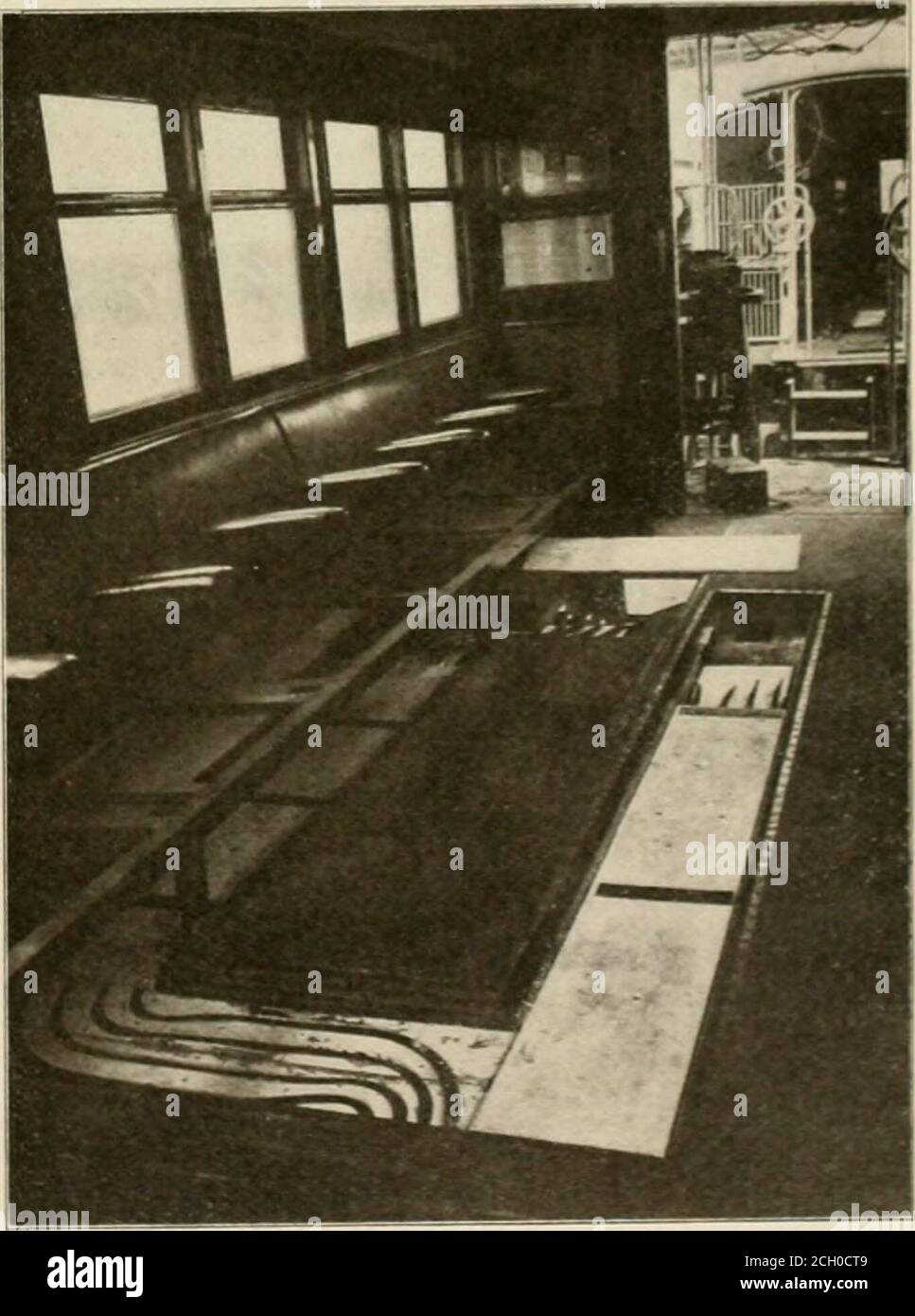 . Die Straßenbahn Bewertung . Raum. Jeder Transformator ist zentral in einer separaten WCu-vcntilated Kammer mit seiner Niederspannungsseite nach der Tür platziert, und eine große Luftwelle rommon zu allen Kammern sorgt für einen Durchzug. In der Decke der Kammern, die der Boden der Galerie ist, sind große Eisenschächte eingesteckt, um das Abziehen der Transformatoren bei Bedarf zu ermöglichen, wobei in den meisten Fällen ein Handkraft-Fahrkrane für diesen und ähnliche Zwecke vorgesehen ist. Im Erdgeschoss hinter den Transformatorkammern befindet sich eine Durchgangserstellung der Hochspannungs-Nil-Break-Schalter Stockfoto