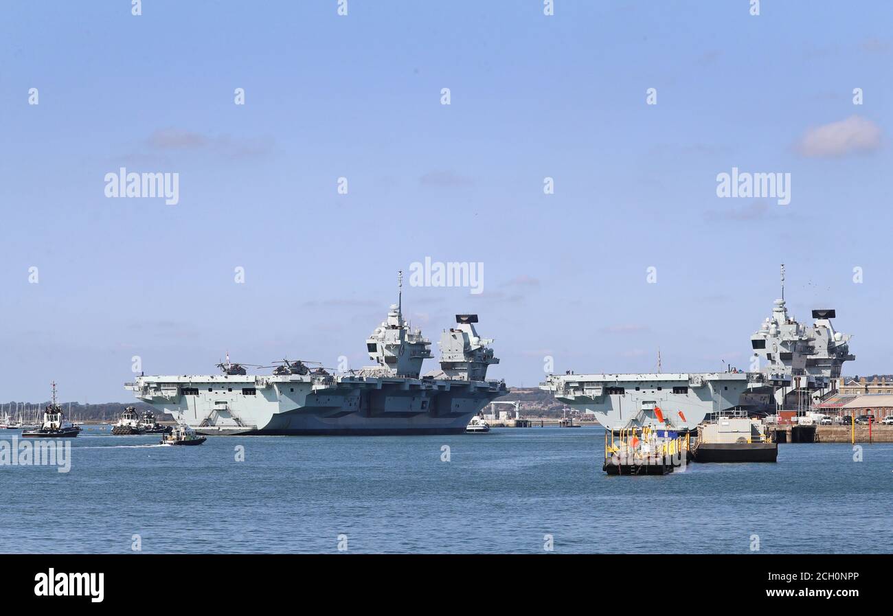 Die Royal Navy Flugzeugträger HMS Queen Elizabeth (links) passiert die HMS Prince of Wales, als sie zurück in Portsmouth Naval Base ankommt, um Vorräte vor dem Segeln für die Übung zu holen, um es für die Carrier Strike Group Bereitschaft vor seinem ersten operativen Einsatz im nächsten Jahr vorzubereiten. Stockfoto