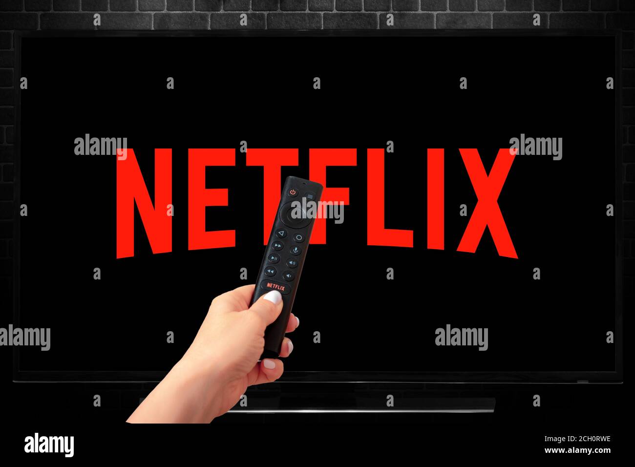 Nahaufnahme von Nvidia Sheild TV Fernbedienung in der Hand und TV-Bildschirm mit Netflix Logo, Netflix ist ein bekannter globaler Anbieter von Streaming-Filme und TV-Serien Stockfoto