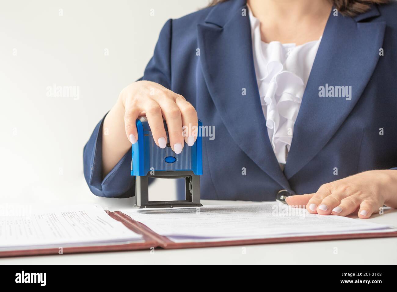 Offizieller Notar, Büroangestellter, der Stempel auf Dokumente legt Stockfoto