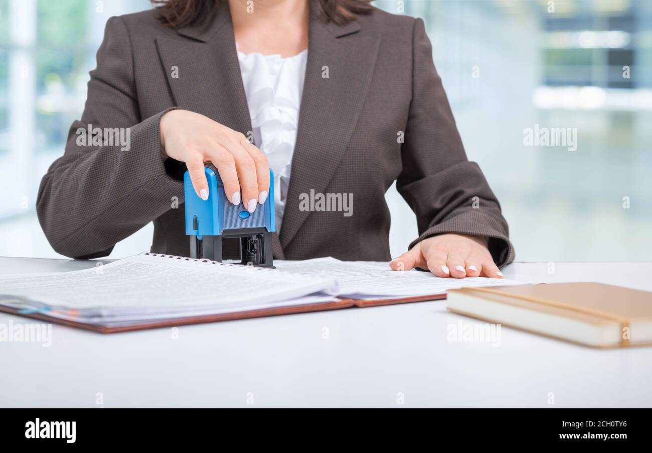 Geschäftsfrau Sekretärin Büroangestellter Putting Stamp auf Dokumente, Vertrag, einen Deal, Office-Konzept Stockfoto