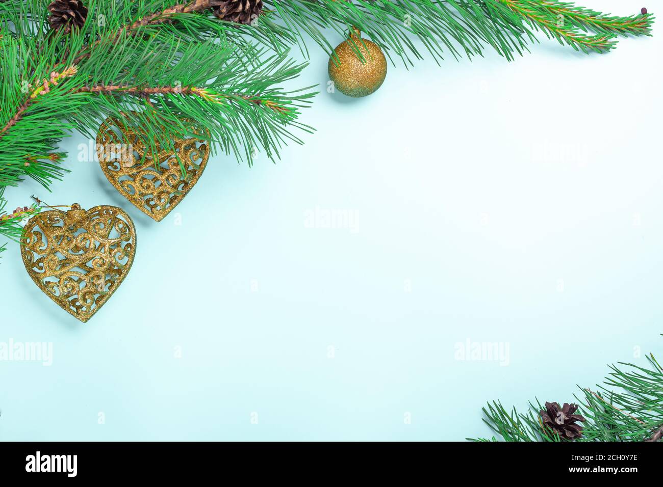 Tannenzweige und Weihnachtsspielzeug. Weihnachts- oder Neujahr-Karte auf hellblauem Hintergrund Stockfoto