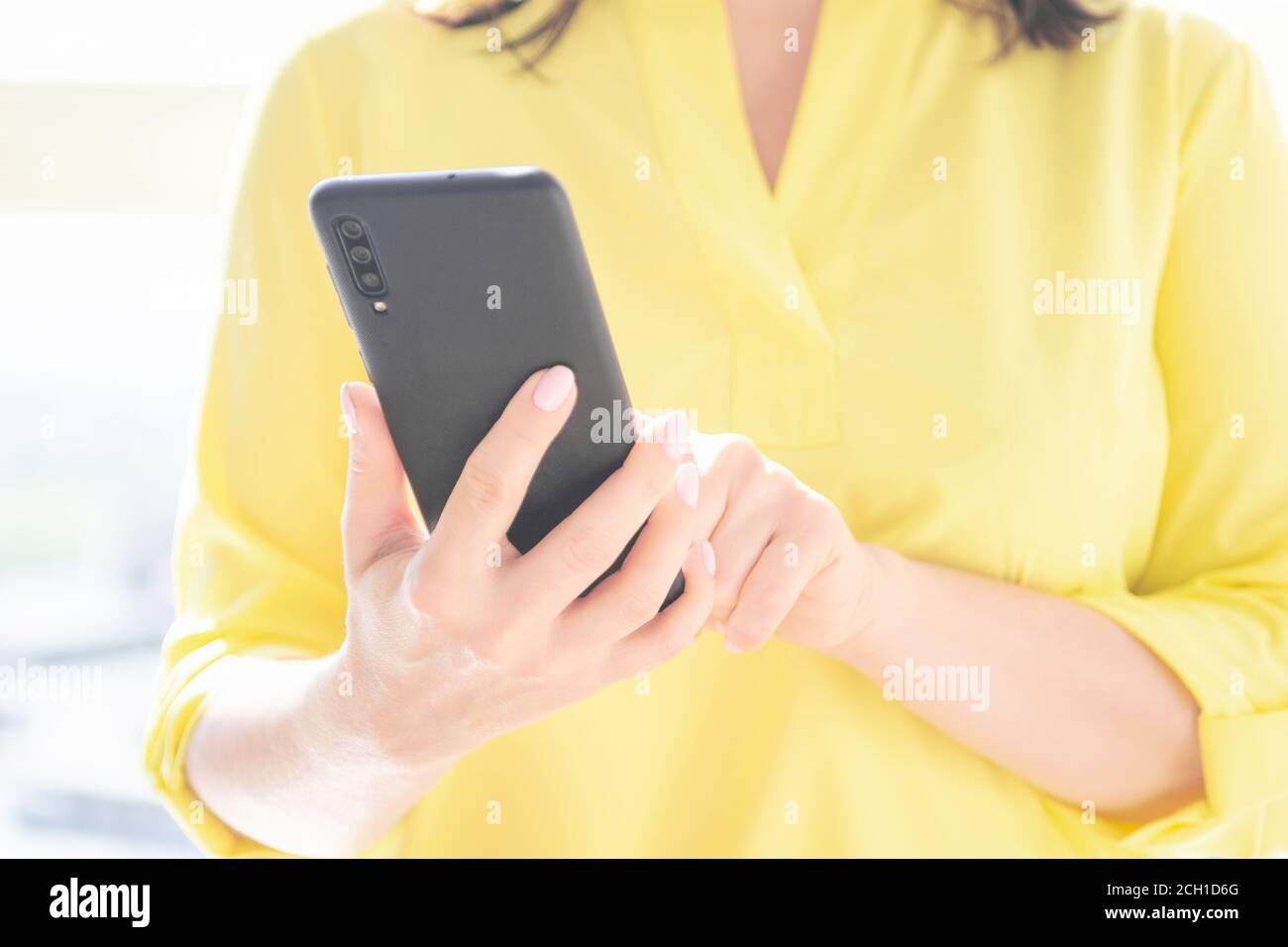 Nahaufnahme der Frauen Hände halten Handy-Smartphone. Die Frau benutzt das Handy. Indoor. Kopieren Sie Platz für Ihre Werbe-Textnachricht oder Werbe-Co Stockfoto