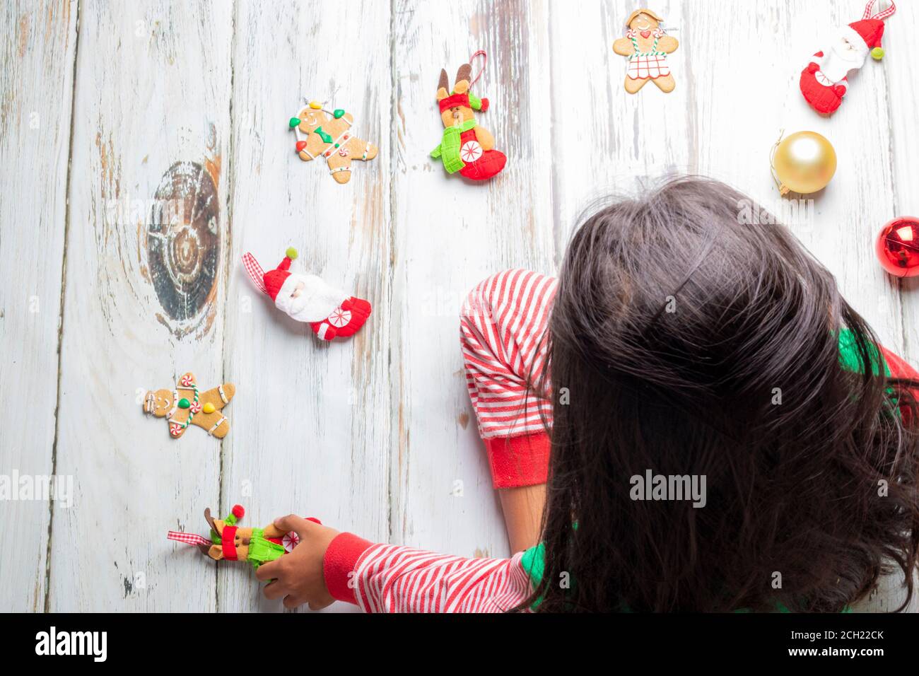 Kleines Mädchen mit Weihnachten Schlafanzug spielen mit Weihnachtsschmuck Stockfoto