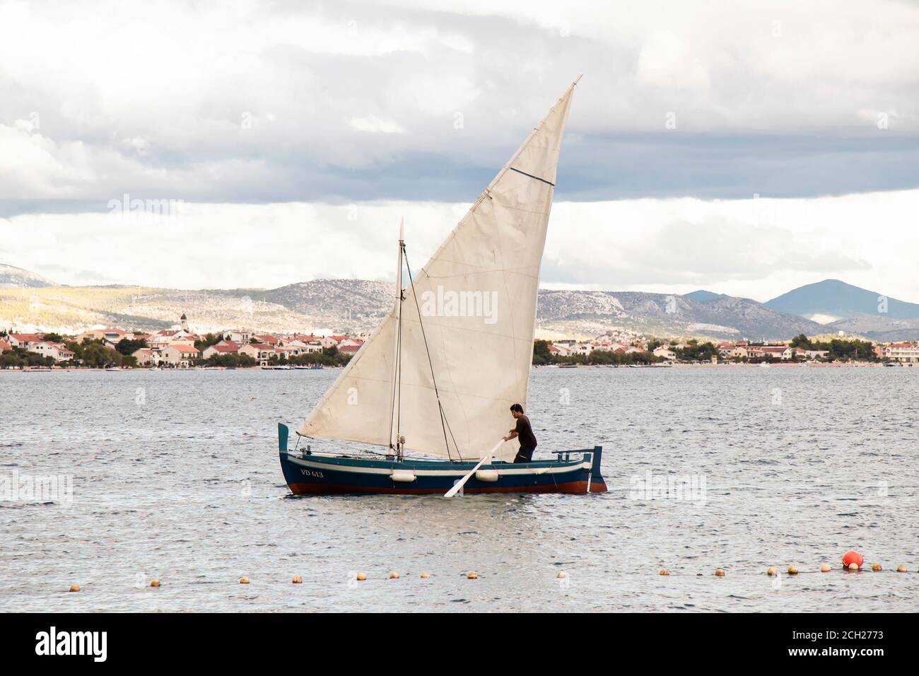 Vodice, Kroatien - 1. September 2020: Mann mit einem Paddel in einem Segelboot Stockfoto