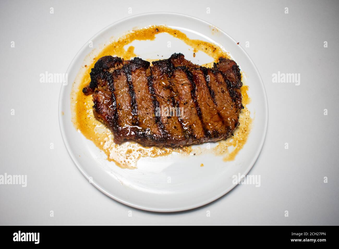 Ein perfekt gegartes Steak mit Grilllinien, die auf einem Reiner Weißer Hintergrund Stockfoto