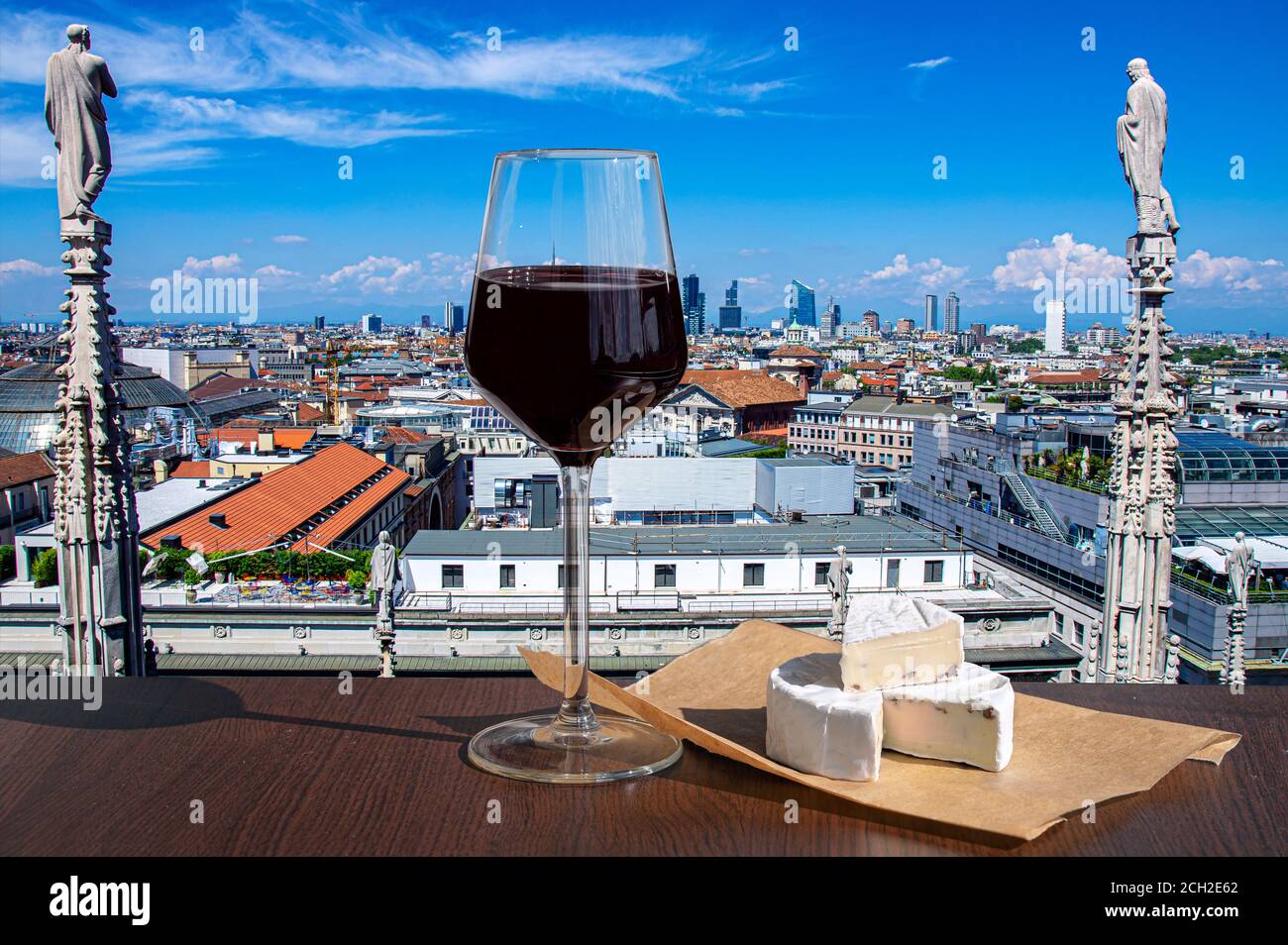 Ein Glas Rotwein mit Brie-Käse gegen den Blick von oben auf Mailand, Italien Stockfoto