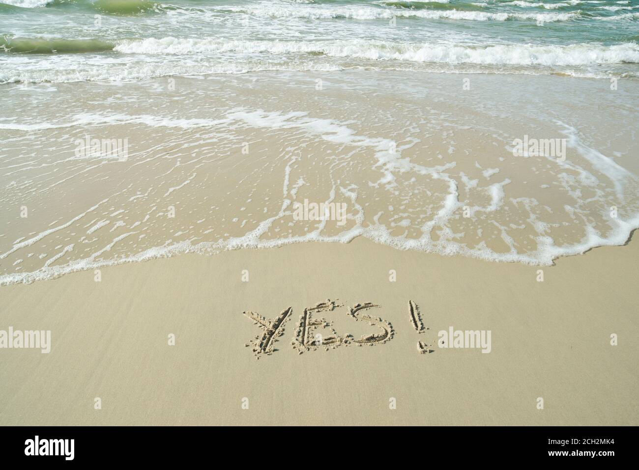 JA, Konzept, Wort geschrieben auf Sandstrand Stockfoto