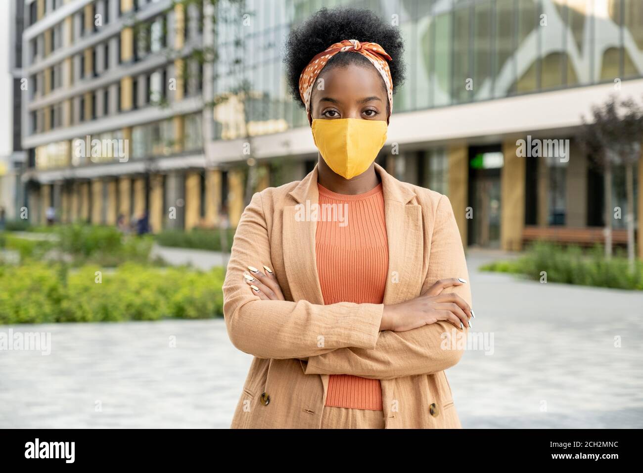 Junge zeitgenössische afrikanische Geschäftsfrau in Casualwear und Schutzmaske Stockfoto