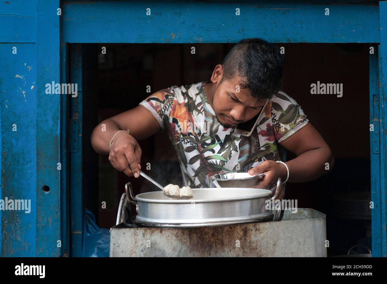 KATHMANDU, NEPAL - 14. AUGUST 2018: Nicht identifizierter nepalesischer Mann, der in seinem Laden in der Straße von Kathmandu, Nepal, Momos kocht Stockfoto
