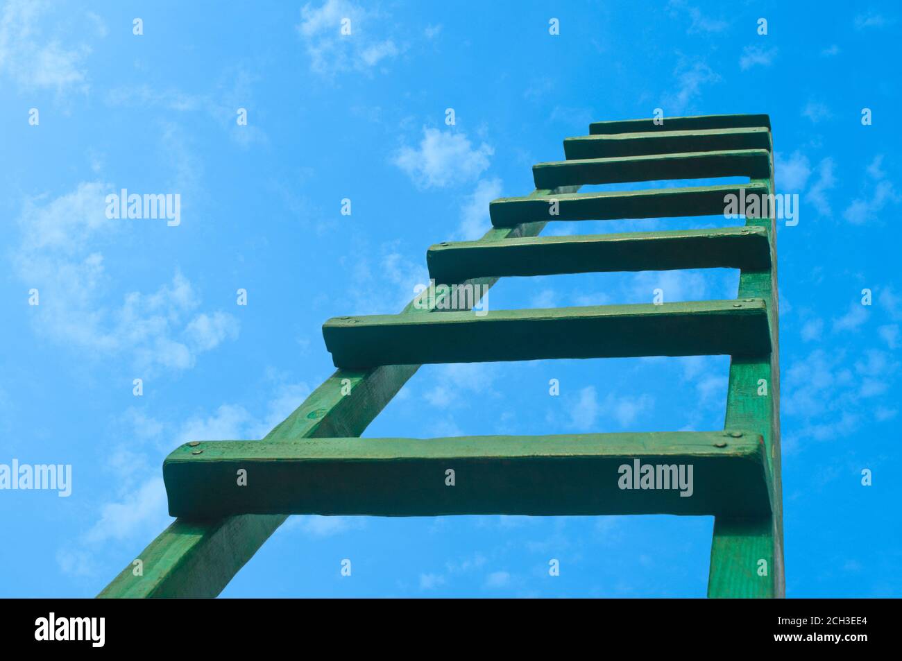 Greifen nach Green Ladder, die zu EINEM blauen Himmel führt Stockfoto