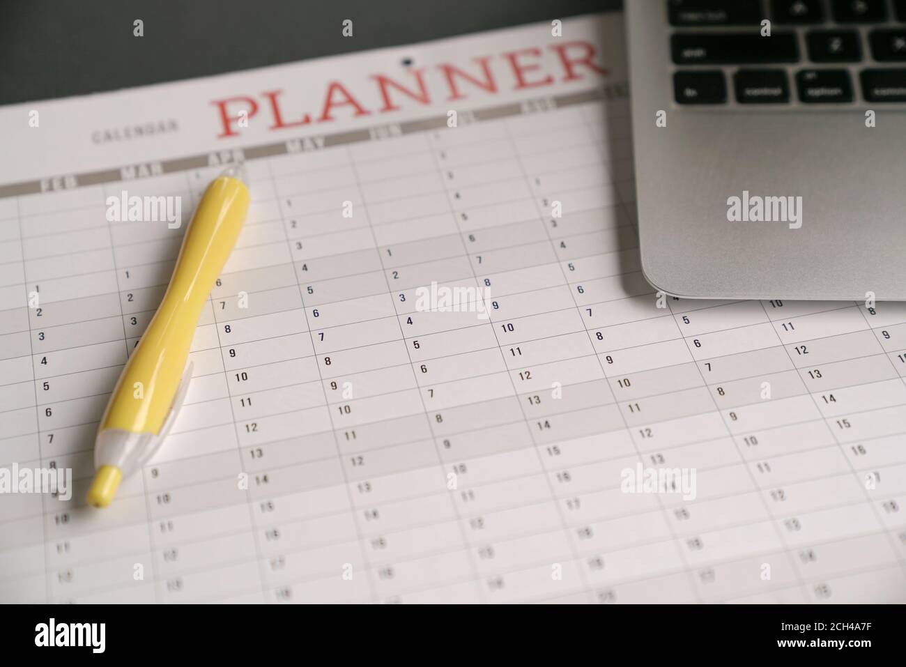 Computer-Laptop und gelber Stift auf dem Kalender Planer Stockfoto