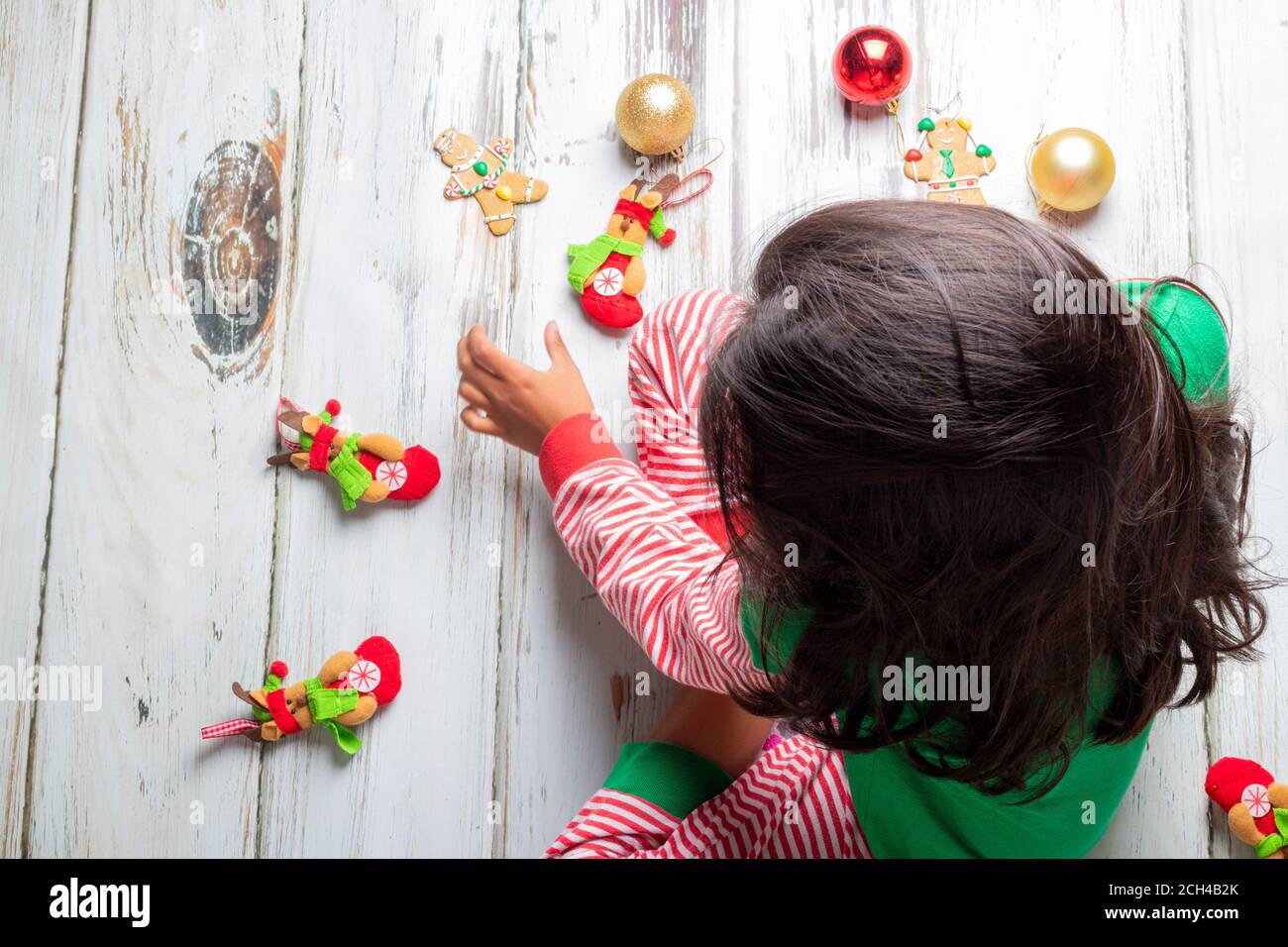 Kleines Mädchen mit Weihnachten Schlafanzug spielen mit Weihnachtsschmuck Stockfoto