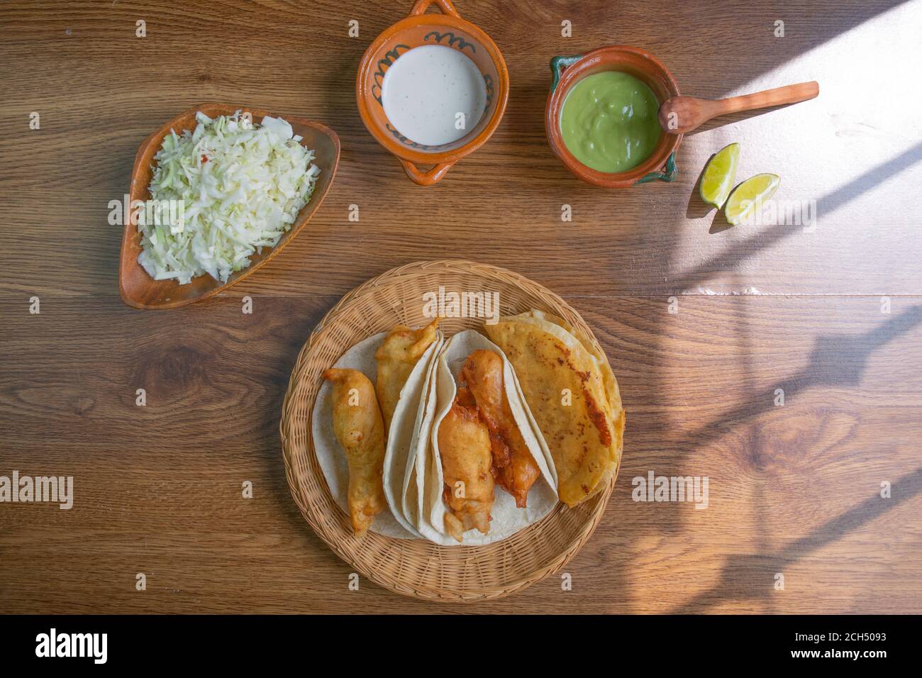 Blick von oben auf Baja California Stil Fisch Tacos mit Guacamole, Sahne und Kohl. Mexikanisches Essen Stockfoto