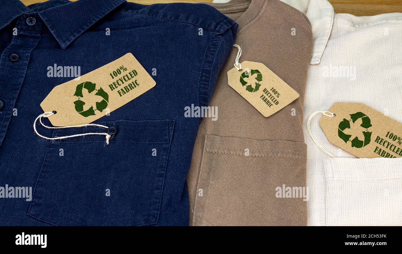 Hemden mit Recycling-Kleidung Symbol auf dem Etikett mit 100% recyceltem Stoff Text. Nachhaltige Mode und ethisches Einkaufen zur Abfallreduzierung Konzept Stockfoto