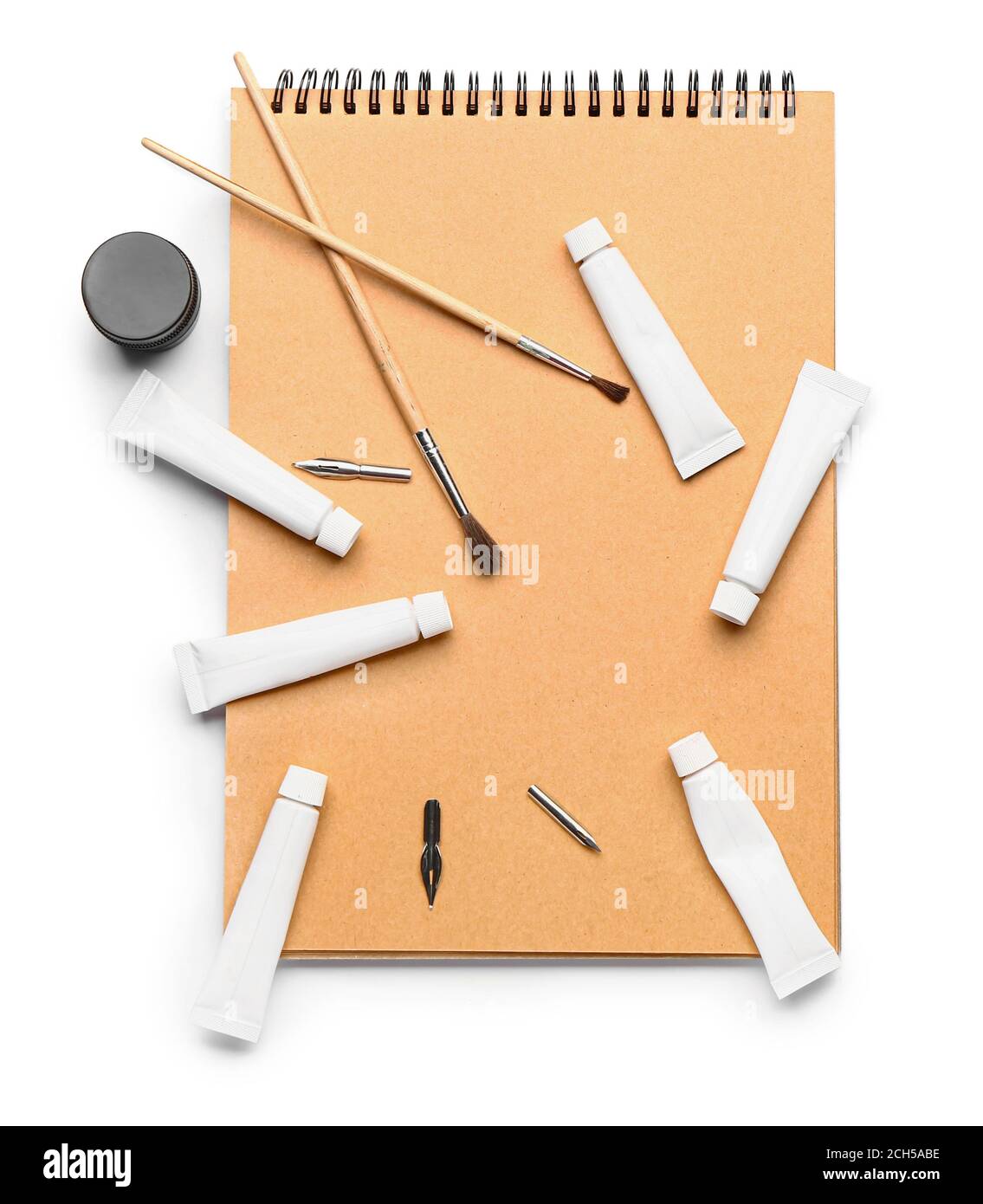 Notizbuch mit Farben und Pinsel auf weißem Hintergrund Stockfoto