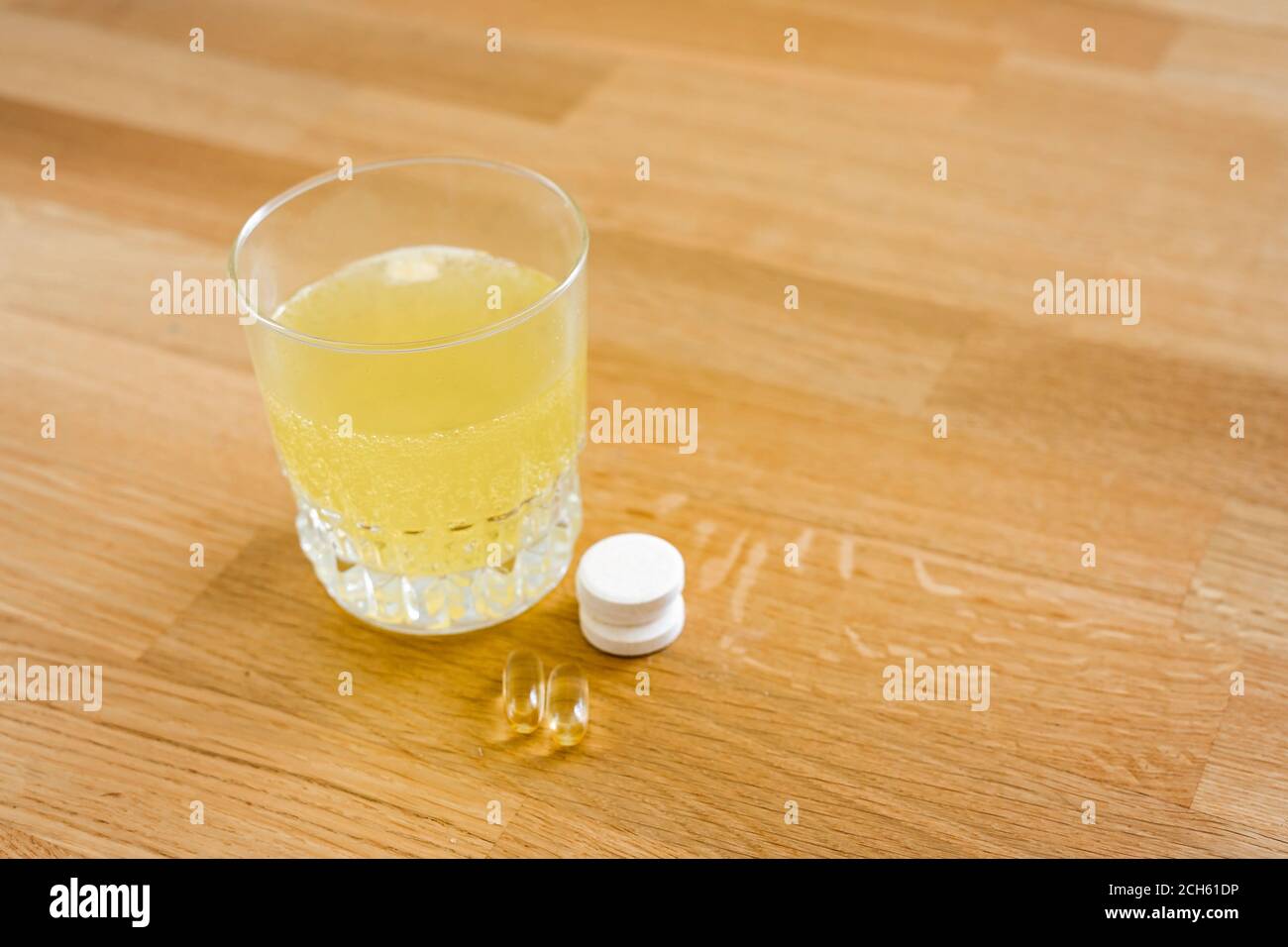 Nahaufnahme Glas mit Wasser und funkelnde Pille. Magnesium Anti-Stress, Schmerzmittel oder Orangengetränk Stockfoto