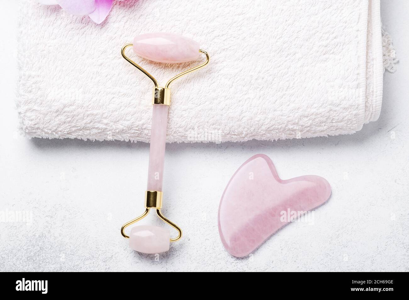 Gua Sha Massagegerät und Gesichtswalze auf Stein Hintergrund. Anti-Age-, Hebe- und Tonungsbehandlung - Bild Stockfoto